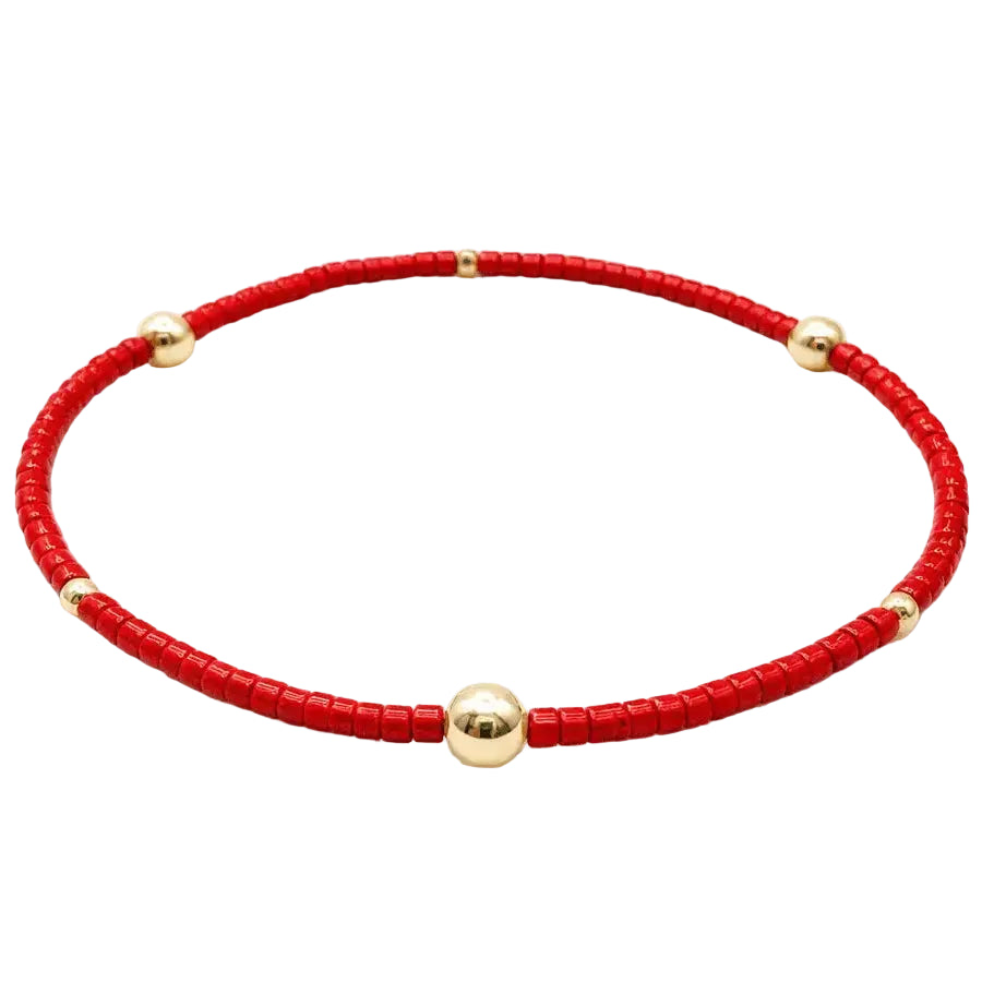 A red beaded bracelet with five polished gold-tone round beads spaced along the front, displayed on a clean white background.
