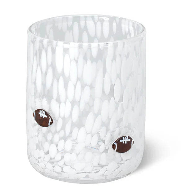 A clear glass tumbler with a hammered texture and two small brown football accents on the front, set against a plain white background.