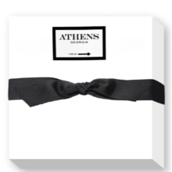 A large white notepad with 'ATHENS GEORGIA 1785 MI' printed on it, wrapped with a black ribbon.