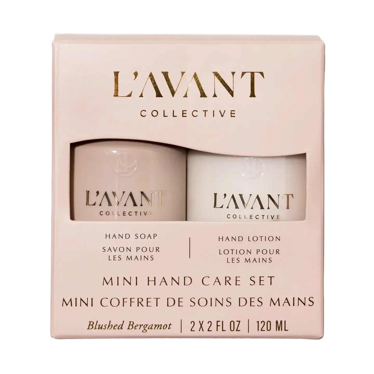 L'Avant Collective Mini Hand Care Set in Blushed Bergamot, featuring a pale blush pink box with two mini bottles visible through a clear window: a hand soap bottle in a warm beige tone and a hand lotion bottle in an off-white tone.