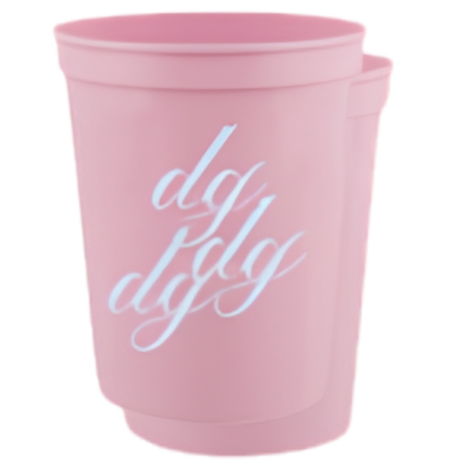 A pink plastic cup with a white cursive script reading 'dg dg' on the front, set against a plain white background.