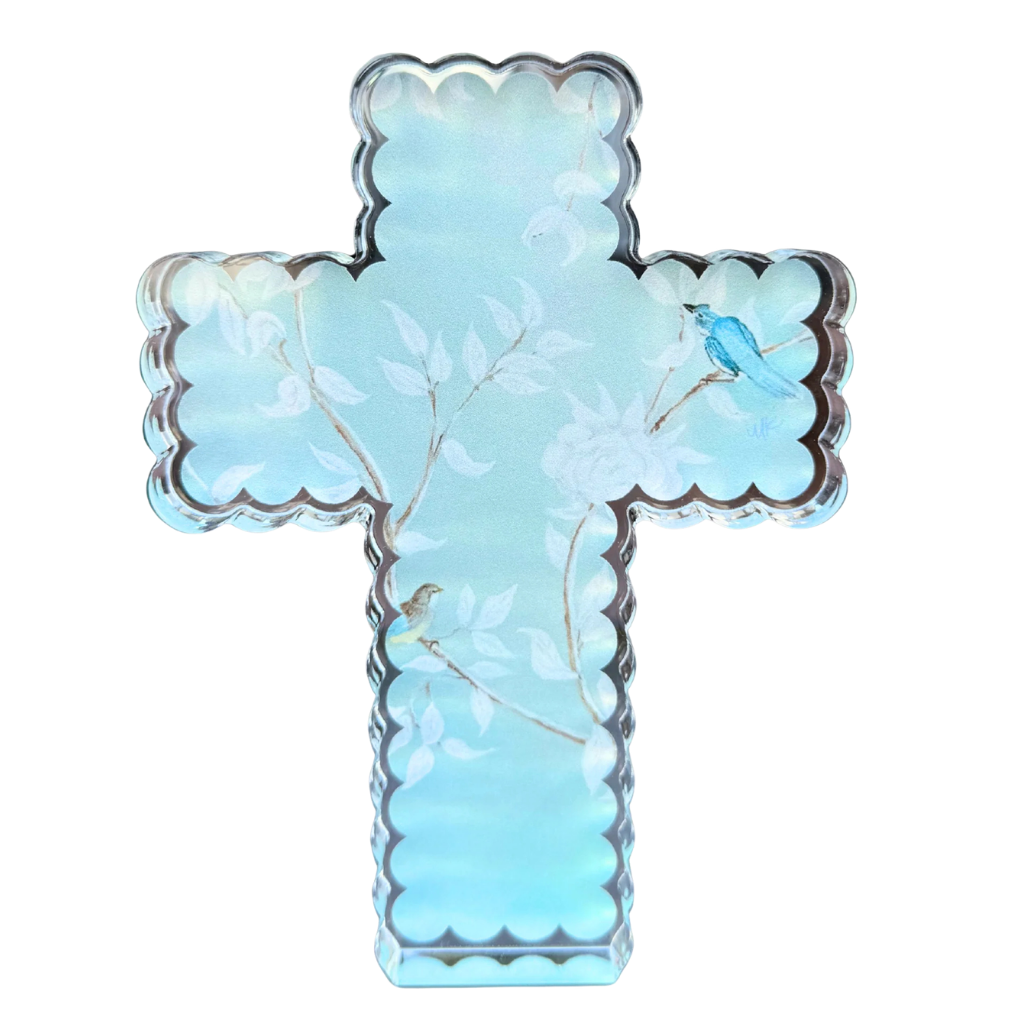 A light blue cross acrylic shelfie with a scalloped edge, featuring a delicate white floral design and a small blue bird.