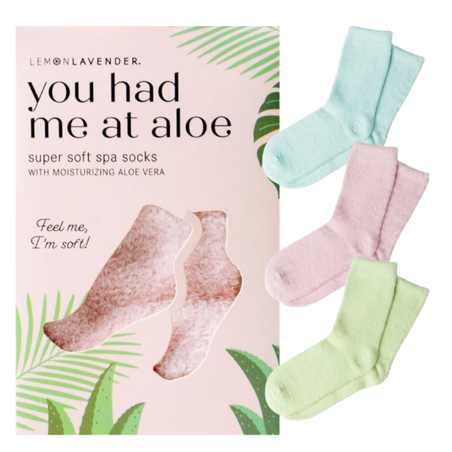 A box of 'You Had Me at Aloe' super soft spa socks, shown next to three pairs of pastel-colored socks in mint green, light pink, and light blue on a white background.