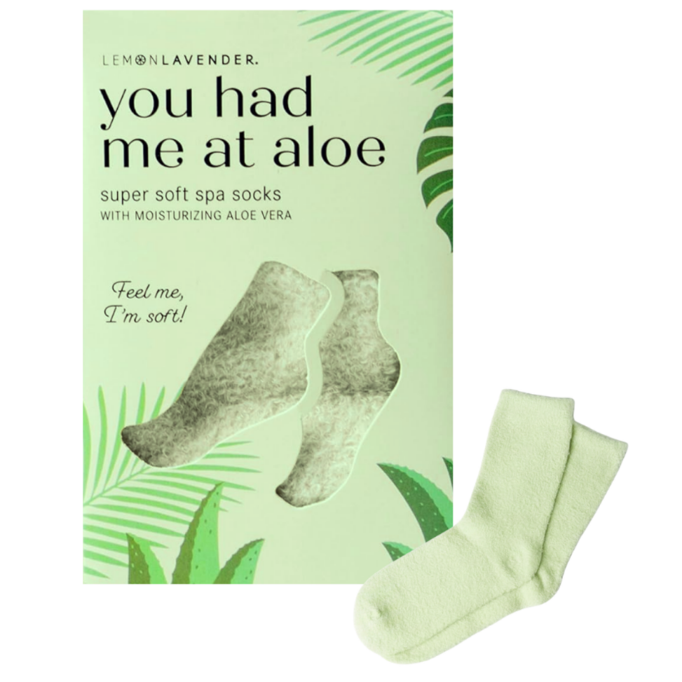 A box of  'You Had Me At Aloe' super soft spa socks, shown next to two light green socks on a plain white background.