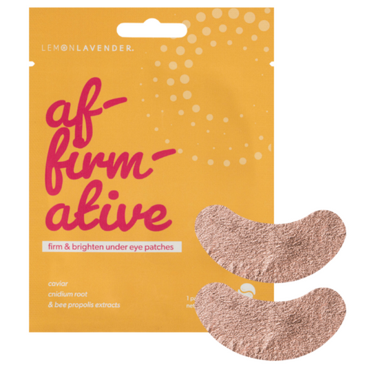 A package of af-firmative eye patches by The Lavender Room, featuring a mustard yellow pouch with pink lettering and two visible beige under-eye patches on a plain white background.