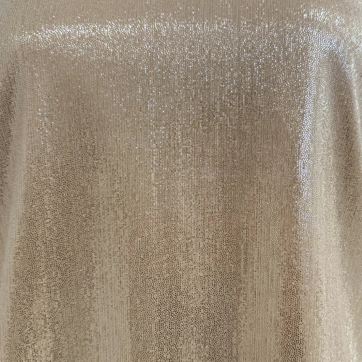 A close-up of shimmering metallic fabric in a champagne gold color, showing a textured, sequined surface with vertical highlights.