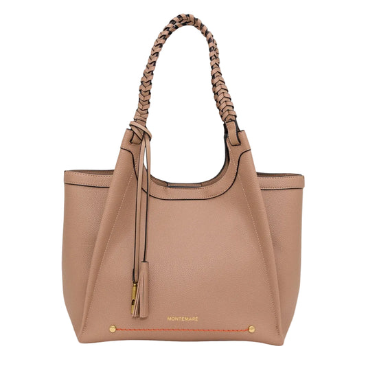 A Montemare leather tote bag in a warm tan color, featuring braided top handles, a hanging leather tassel charm, and gold-tone hardware on a light gray background.
