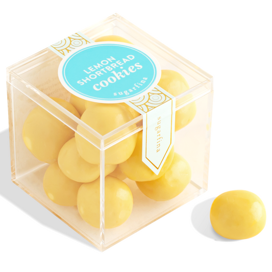 Clear cube container with yellow cookies and a blue label on a white background