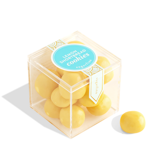 Clear cube container with yellow cookies and a blue label on a white background