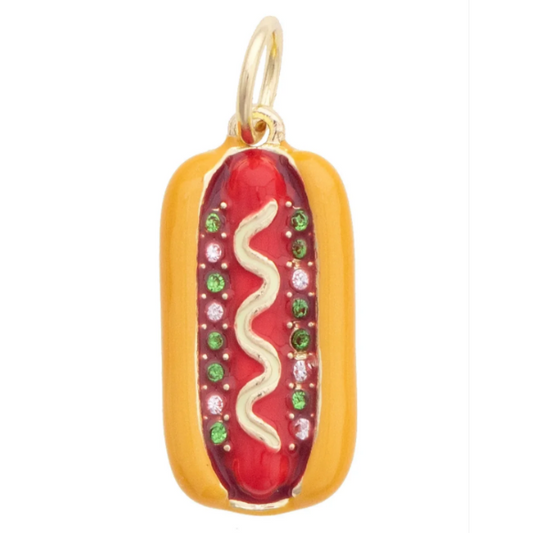A gold-toned hot dog pendant charm featuring a red center with a wavy white line and small pink and green jewels, shown on a plain white background.