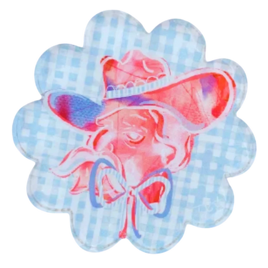 A scalloped circular patch featuring a light blue and white gingham pattern with a central pink watercolor illustration of a cowgirl in a hat.