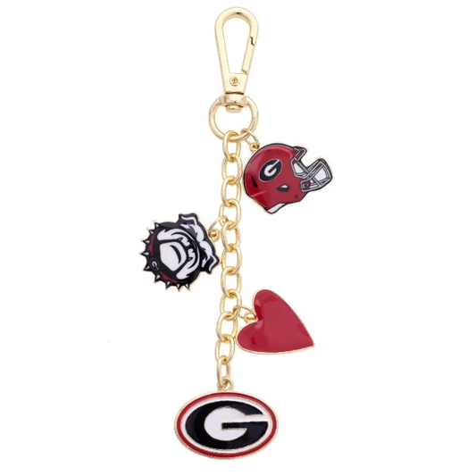 A gold-tone metal charm keychain featuring multiple Georgia Bulldogs themed charms, including a red football helmet, a red heart, a bulldog skull, and an oval Georgia 'G' logo charm, set against a plain white background.