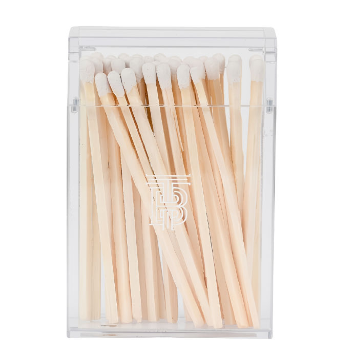 A clear plastic rectangular matchbox containing light wood matches with white tips, shown on a plain white background.