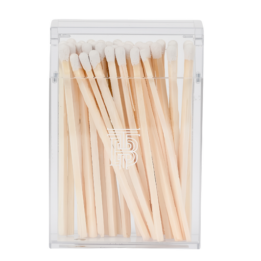 A clear plastic rectangular matchbox containing light wood matches with white tips, shown on a plain white background.