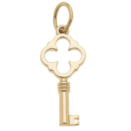 A gold key-shaped pendant charm with a decorative clover-like top and a small loop at the top, shown on a plain white background.