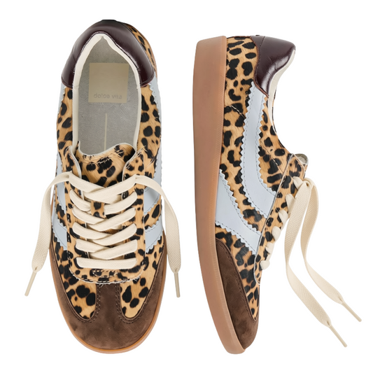 A pair of low-top sneakers shown from the top and side views on a plain white background. The shoes feature a beige and black leopard print upper with light blue suede side stripes, brown leather toe caps and heel tabs, cream laces, and a gum brown sole.
