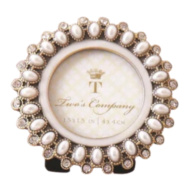 A round decorative picture frame with a beaded silver-toned border and a cream center, displayed on a small black stand against a plain white background. The center features the brand name 'Laura's Company' with a crown logo.