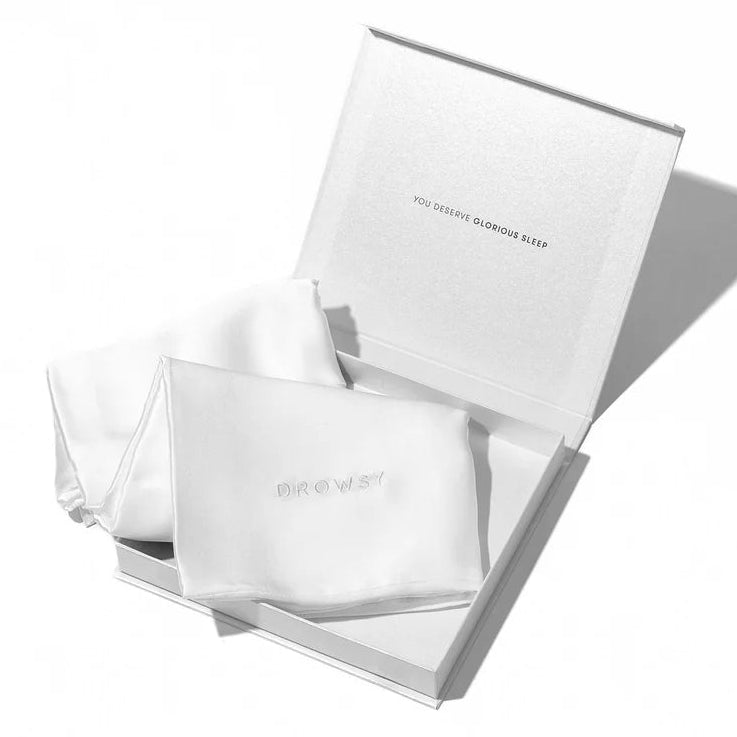 An open white presentation box containing two white square pouches, one of which is embossed with the brand name 'eye view'. The packaging is photographed on a clean white background with a soft shadow cast to the right.