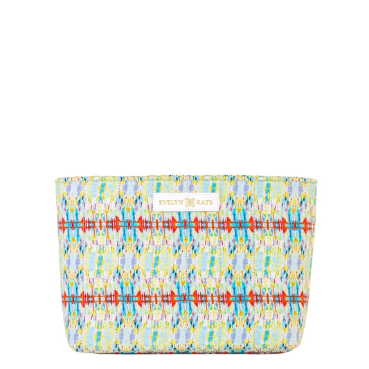 A rectangular cosmetic pouch by Evelyn + Kate featuring a colorful geometric ikat pattern on a white background, with a small white brand label on the front.