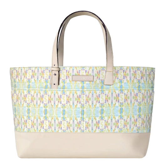 A tote bag with a cream-colored base and handles, featuring a colorful ikat patterned upper body in shades of blue, green, yellow, and pink on a white background.