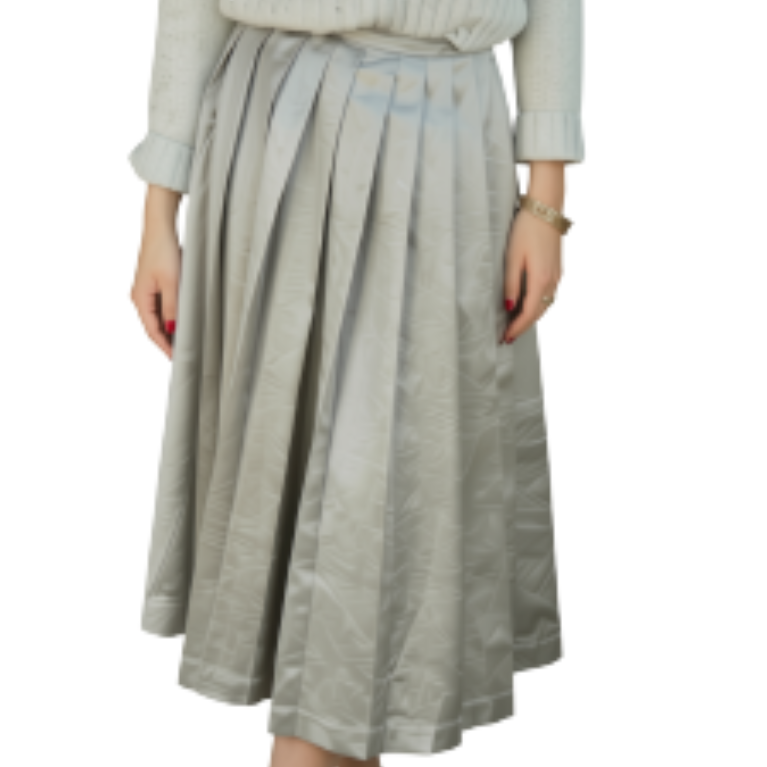A model wearing a light sage green pleated midi skirt with a matching embroidered top, shown against a plain white background.