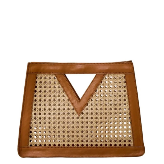 A rectangular clutch bag featuring a natural woven cane or rattan body with a warm brown leather trim and a V-shaped leather handle, shown against a plain white background.