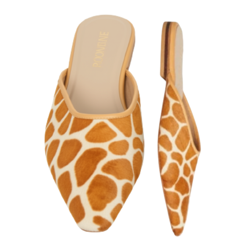 A pair of pointed-toe mule heels shown on a plain white background, with one shoe from the top and one from the side. The upper is made of a giraffe-print material in tan and cream, and the sole is black.