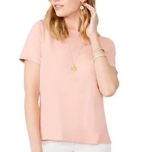 A woman wearing a light pink short-sleeve crewneck top and white pants, shown against a plain white background.