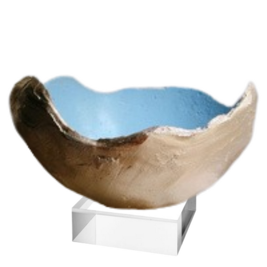A handmade ceramic bowl with a textured, organic shape, featuring a light blue interior and a brown and beige exterior, displayed on a clear acrylic stand against a white background.