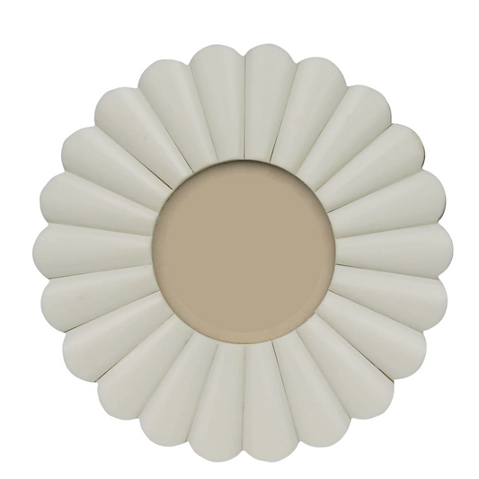 A round decorative mirror with a sunburst or daisy-like frame in a warm off-white/cream color, featuring a central beige insert.