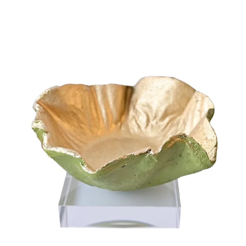 A decorative bowl with a textured, organic ruffled edge, featuring a metallic gold interior and a matte green exterior, displayed on a clear acrylic stand against a white background.