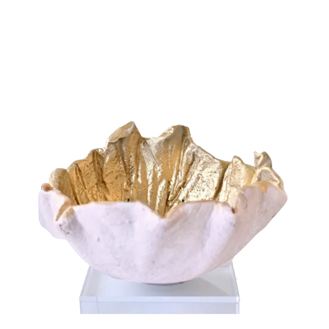 A decorative bowl with a textured, organic shape, featuring a metallic gold interior and a pale pinkish-white exterior, displayed on a clear acrylic stand against a white background.
