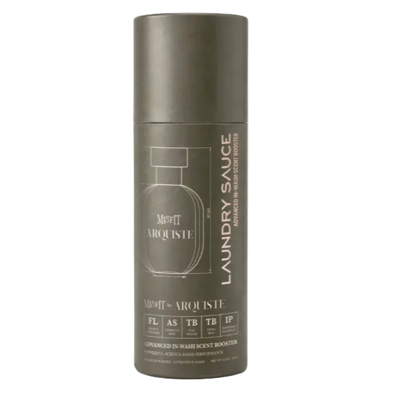 A matte dark gray cylindrical bottle of Misfit by Arquiste Laundry Sauce, featuring a minimalist line-art bottle graphic and text, set against a clean white background.