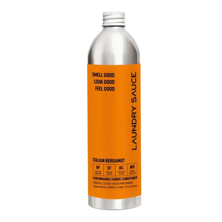 A silver aluminum bottle of Laundry Sauce Italian Bergamot performance fabric conditioner with a bright orange label, centered on a light gray background.