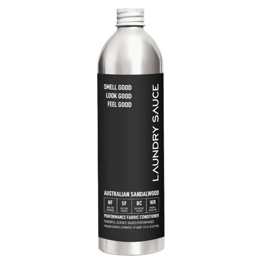 A silver aluminum bottle of Laundry Sauce Australian Sandalwood performance fabric conditioner with a black label, shown on a white background with black arrows on the sides.