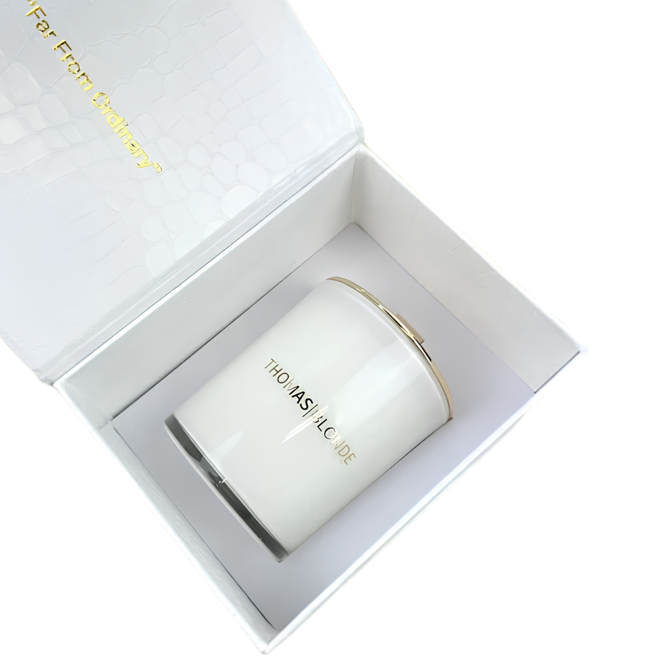 A white jar candle with gold lettering reading 'THE ASH & LEAVES' sits inside an open white gift box with a textured lid and gold branding.