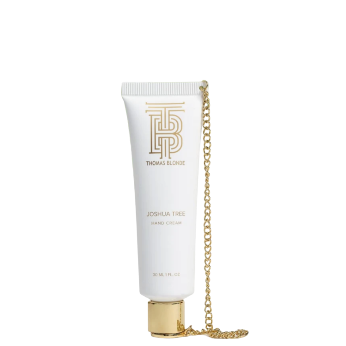 A white squeeze tube of Tracee Slore Joshua Tree Hand Cream with a gold cap, featuring a gold chain draped over the side and a gold monogram logo on the front.