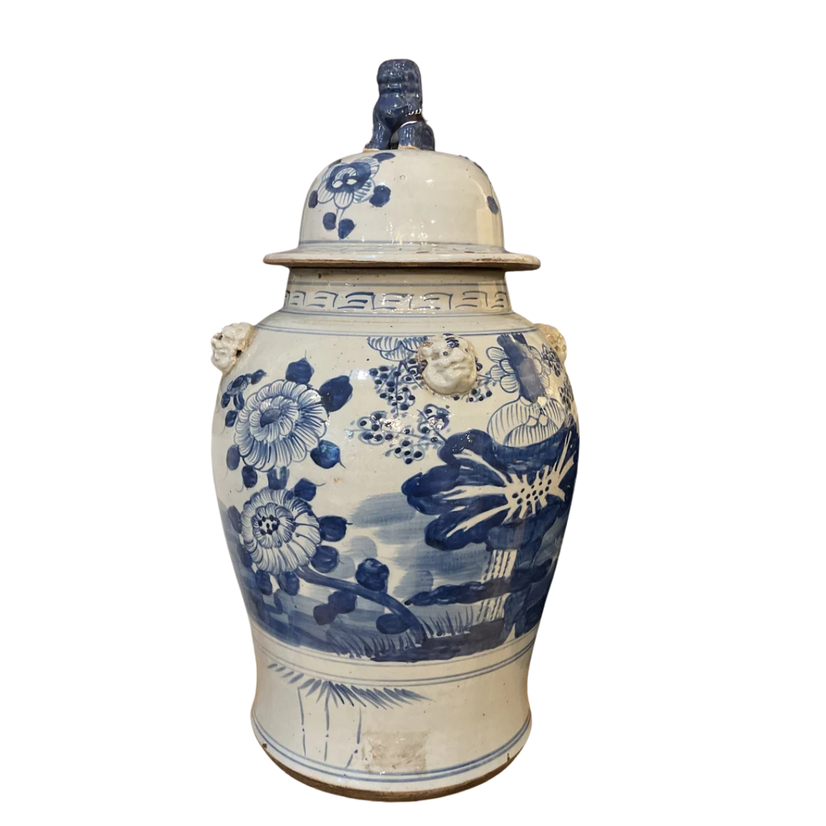 A large blue and white porcelain ginger jar with a lid and side handles, shown alongside two smaller matching jars on a plain white background.